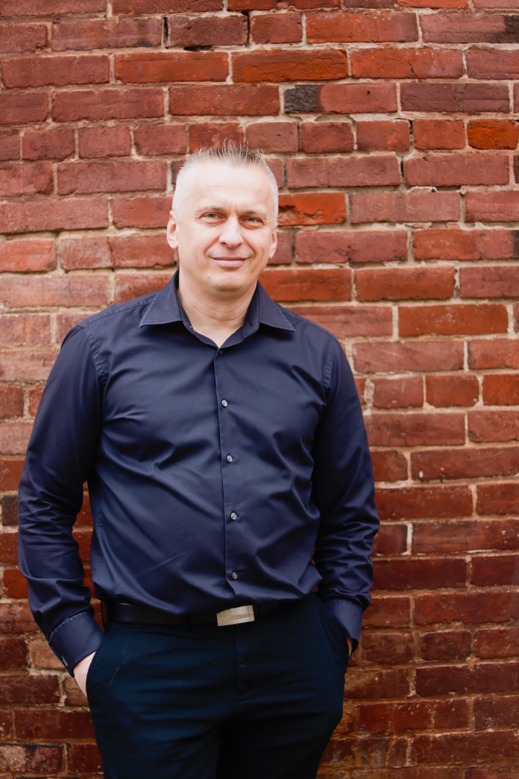 Stan Tscherenkow standing against a brick wall