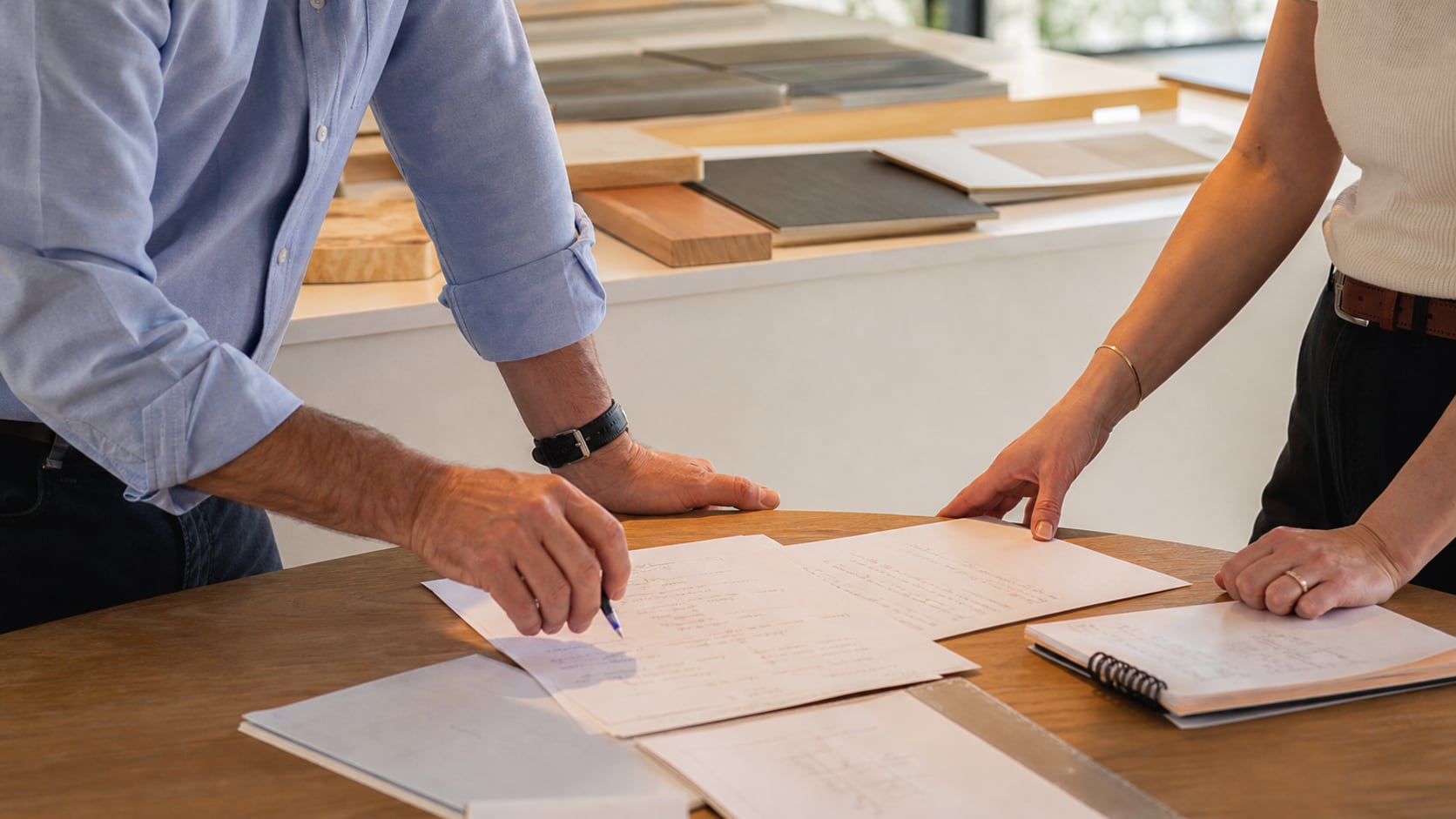 Two business operators going over revised offer notes and sample work after a buyer conversation.