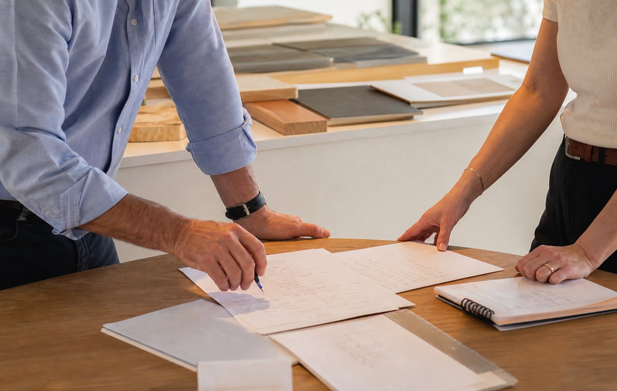 Hands over revised business notes, sample work, and unreadable capacity planning after a buyer conversation.